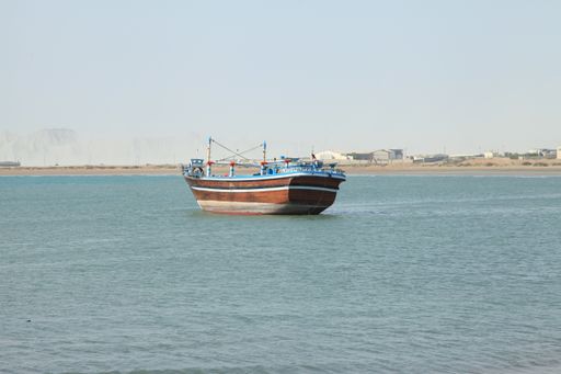 An aerial shot of a beautiful wooden boat floating on a blue water