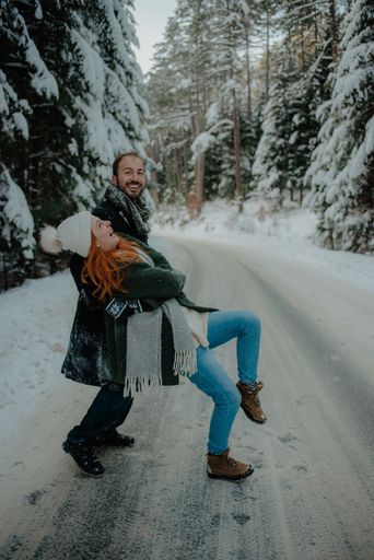 A Beautiful view of a couple wearing warm clothes having fun at the snow park