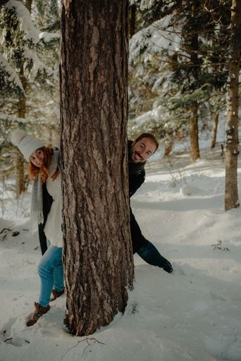 A Beautiful view of a couple wearing warm clothes and having fun at the snow park