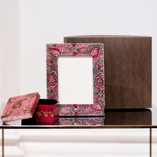 A closeup of a photo frame and a mockup with colorful floral patterns on the table