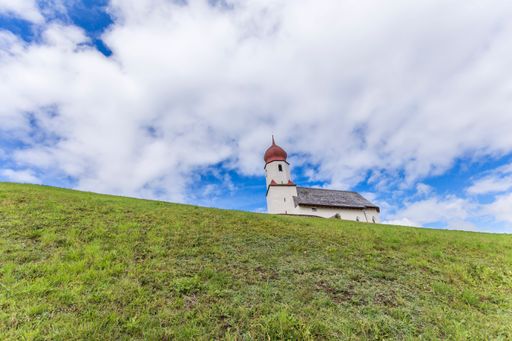 A breathtaking view of an ancient church situated atop a hill in Vorarlberg, Austria