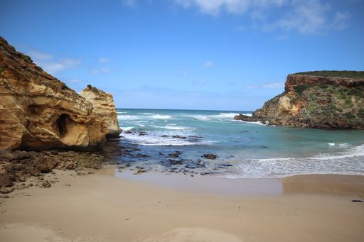A beautiful view of a sandy beach with rocks during sunrise
