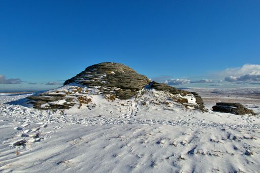 A large rock formation standing on the Willhays peak with an idyllic winter landscape in background