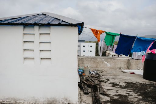 A white house rooftop with laundry hanging from a rope on a gloomy day