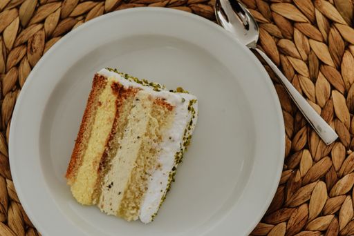 A piece of a cream cake on a plate on a wooden surface