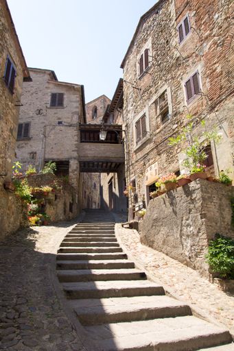 A vertical shot of an ancient staircase surrounded by buildings in Tuscany, Italy