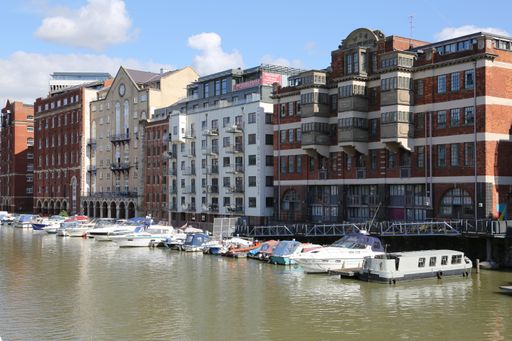 A side shot of buildings next to the river with docked boats in Bristol, UK