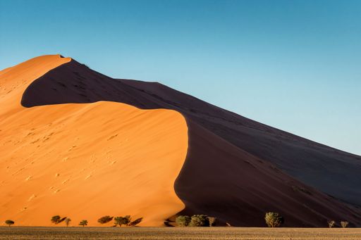 A beautiful shot of a mountain of sand dunes under a clear blue sky