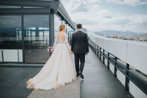 a beautiful shot of a bride and bridegroom from the back holding hands walking toget