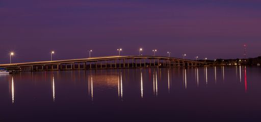 The view of street lights of Queen Isabella Causeway reflecting on the water at night