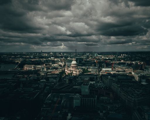 A dramatic night sky featuring storm clouds over the skyline of London, England