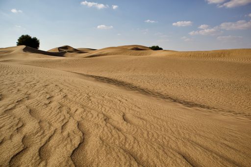 A beautiful shot of a dry brown desert under a bright blue sky