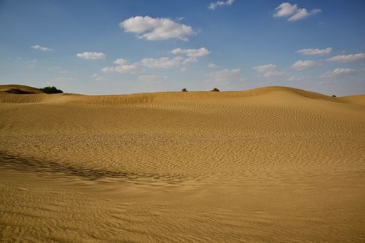 A beautiful shot of a dry brown desert under a bright blue sky
