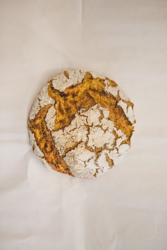 An overhead shot of a freshly baked round bread on an isolated background