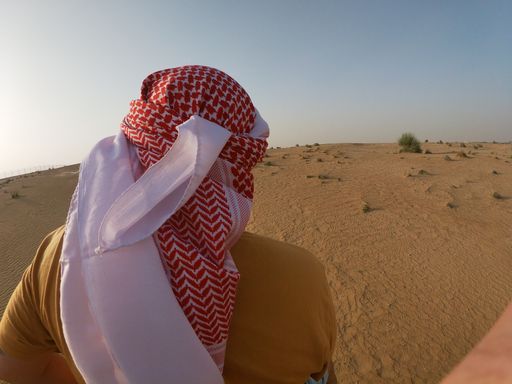 An Arab man wearing a keffiyeh in a desert