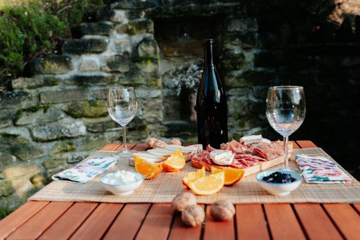 Picnic table with sausages, cheese and traditional Italian food and wine