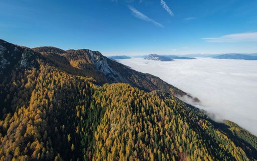Aerial view of Schwarzkogel mountain in Carinthia, Austria on a sunny day, featuring lush green valleys