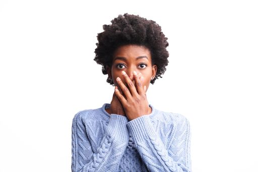 A surprised black female with a blue shirt isolated on a white background