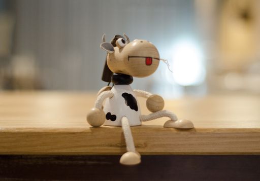 A closeup shot of a wooden cow toy on the table