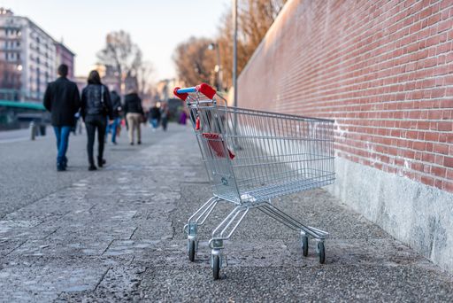 A shallow focus shot of a shopping cart placed in the walkway with a blurred background