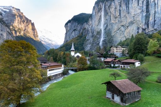 A beautiful Waterfall at Lauterbrunnen Village with houses and a church in Switzerland