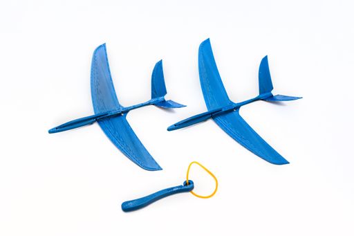 Two blue toy planes and rubber band isolated on white background