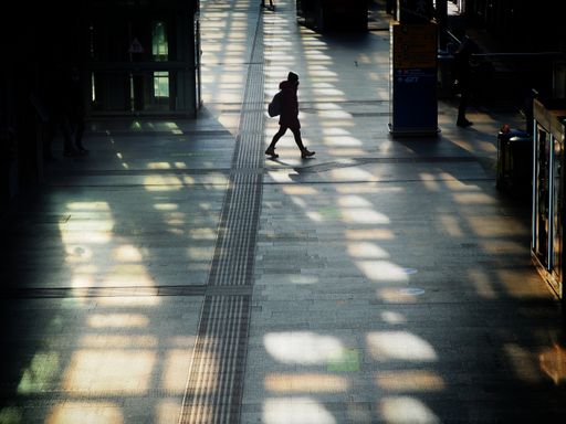 Woman silhouette walking wearing protective mask in train station