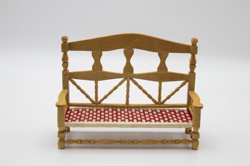 A miniature wooden sofa isolated on a white background