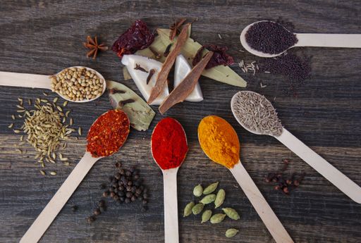 A top view of the spices in the wooden spoon on a table