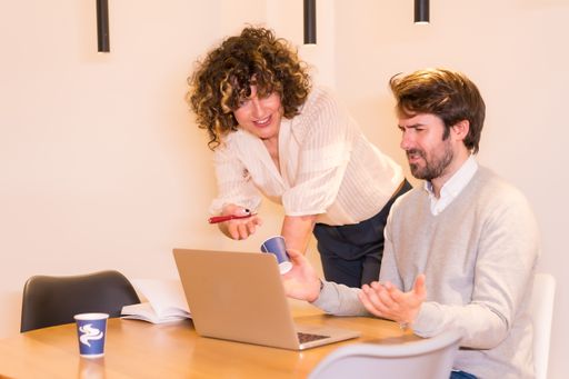 A male and a female discussing a project around a round table at the office