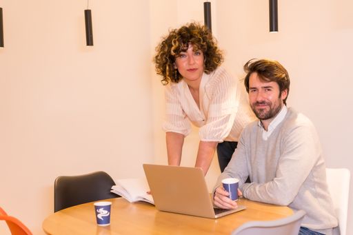 A male and a female discussing a project around a round table at the office