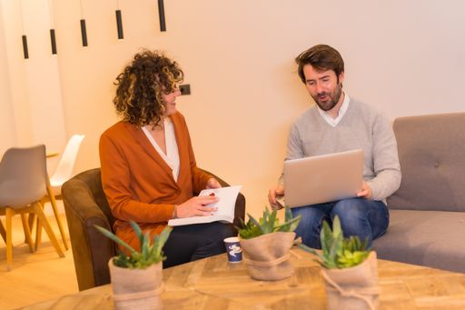 A male and a female discussing a project in front of a table at the office