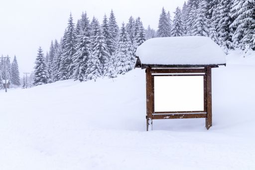 A view of an empty billboard with copy space for advertising poster and snowy fir trees background