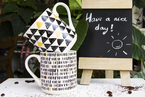 Empty coffee mugs and ''Have a nice day" text message on the blackboard on a restaurant table