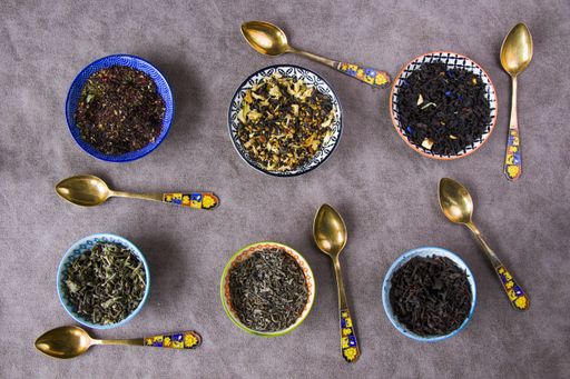 A top view of the herbal and natural dry tea variation in bowls with  vintage spoons