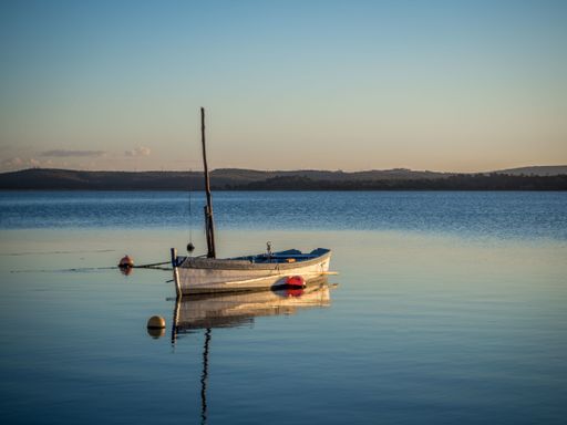 A fishing boat at the river with the beautiful sunset in the background