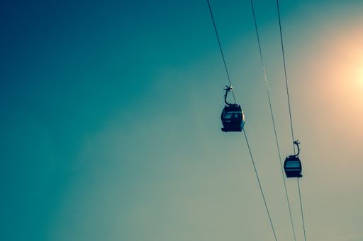 A low angle shot of two cable cars under the beautiful bright sky