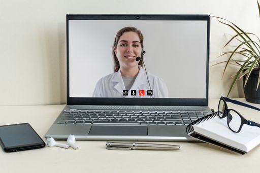 A female Caucasian doctor working online in a telemedicine consultation with a patient