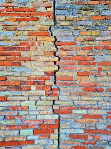 An old brick wall split by a crack