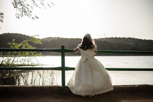A beautiful view of a young girl in a white elegant dress enjoying the view at sunny day