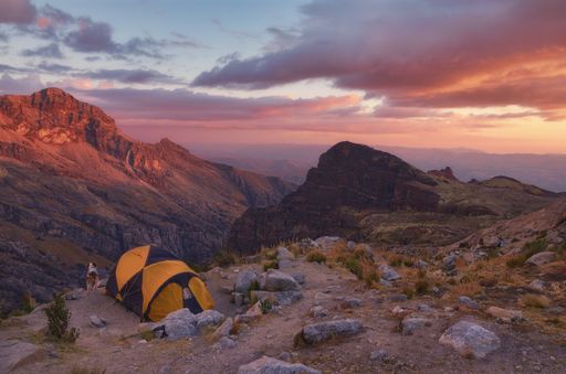 A magical view of the mountains gleaming under the sunset piercing through the pink clouds in the park