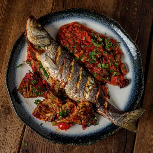 A top view of a fish with sauce in a plate