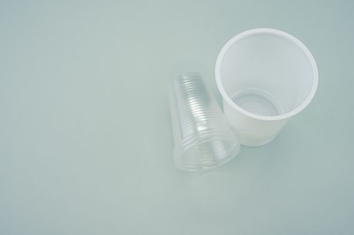 A high angle shot of big and small plastic cups on a blue surface