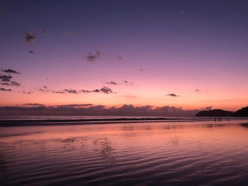 A breathtaking pink and purple sunset cloudscape reflected in the sea - beautiful wallpaper
