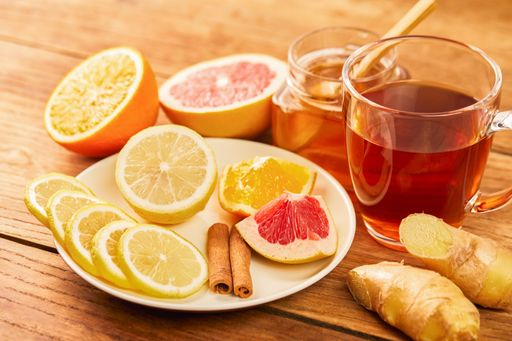 Fresh citrus, cinnamon, ginger, honey and a cup of hot tea on a wooden table