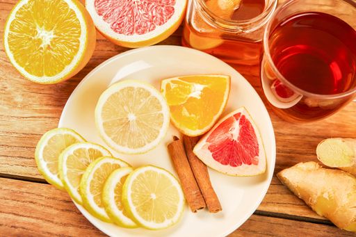 Fresh citrus, cinnamon, ginger, honey and a cup of hot tea on a wooden table