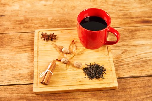 A mug of mulled wine, ingredients and tea on a chopping board