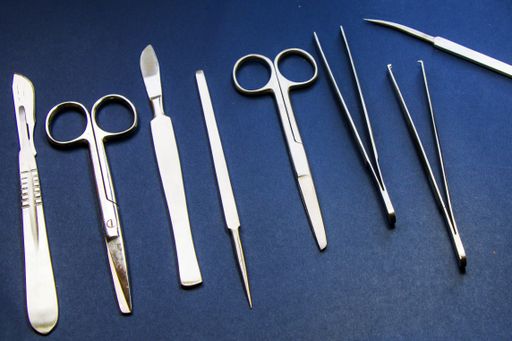 A top view of set of stainless dissecting kits against blue background