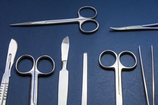 A closeup of dissection kit tools on blue surface