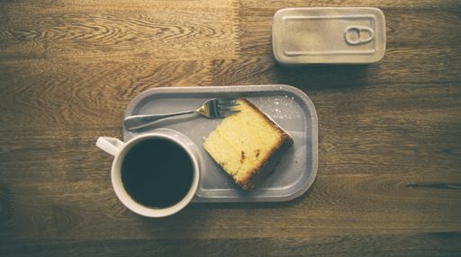 A top view of a coffee mug near a dessert on a wooden table